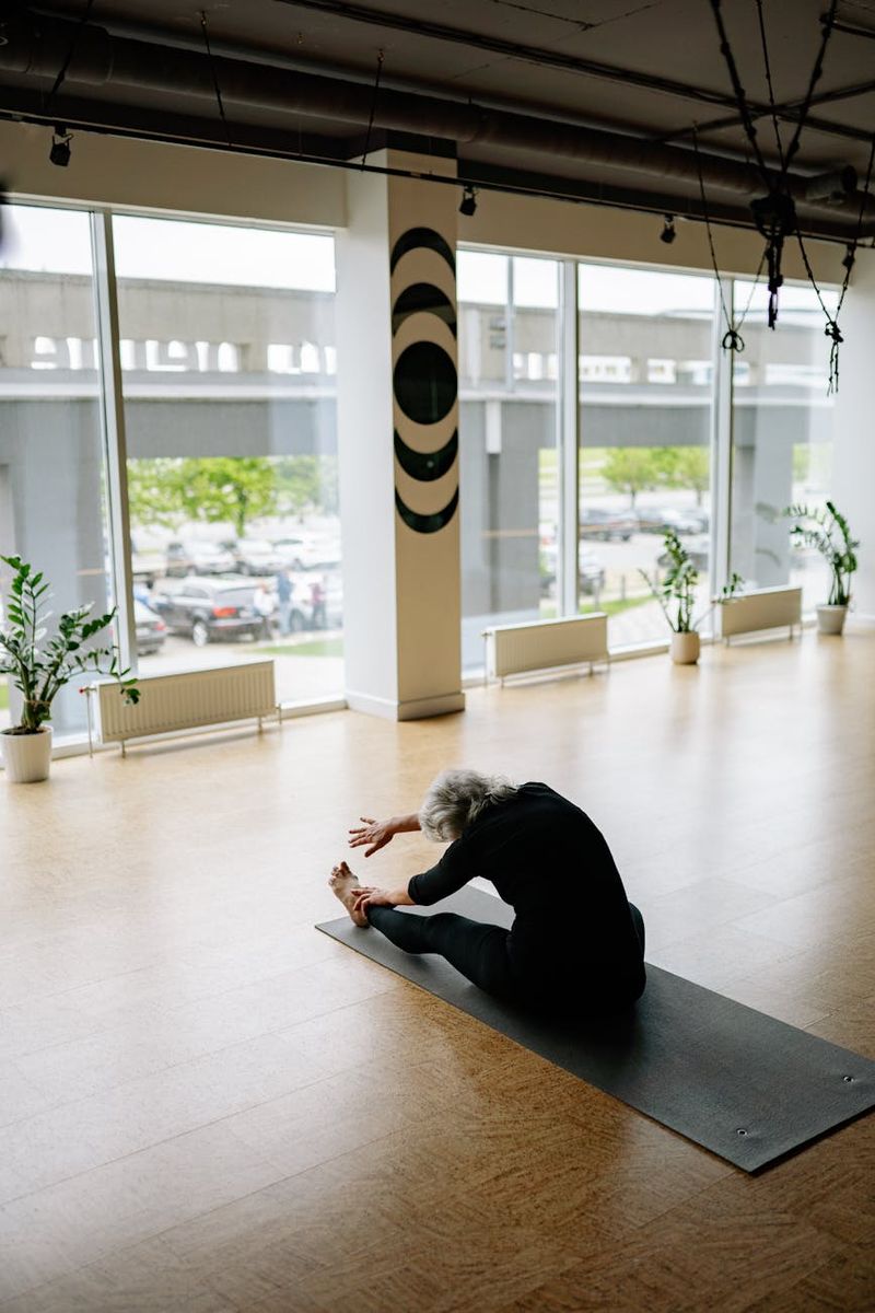 A person in a focused yoga pose inside a modern, spacious room.